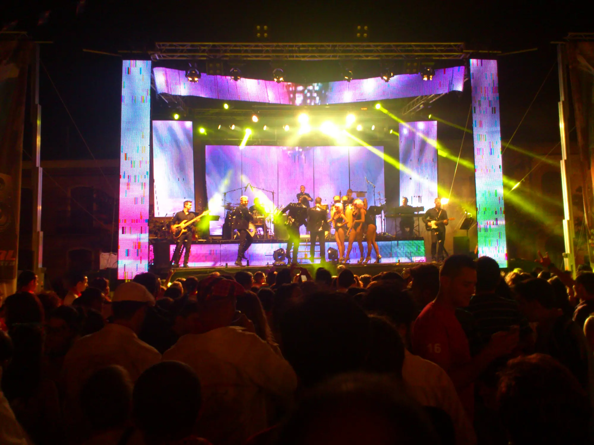 La multitud baila de noche delante del escenario de una orquesta en la plaza mayor de Pedrajas de San Esteban